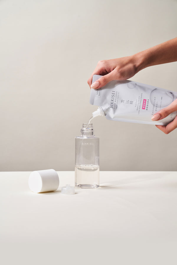 A person refilling Sekkisei Clear Wellness Balancing Liquid into the packaging. 