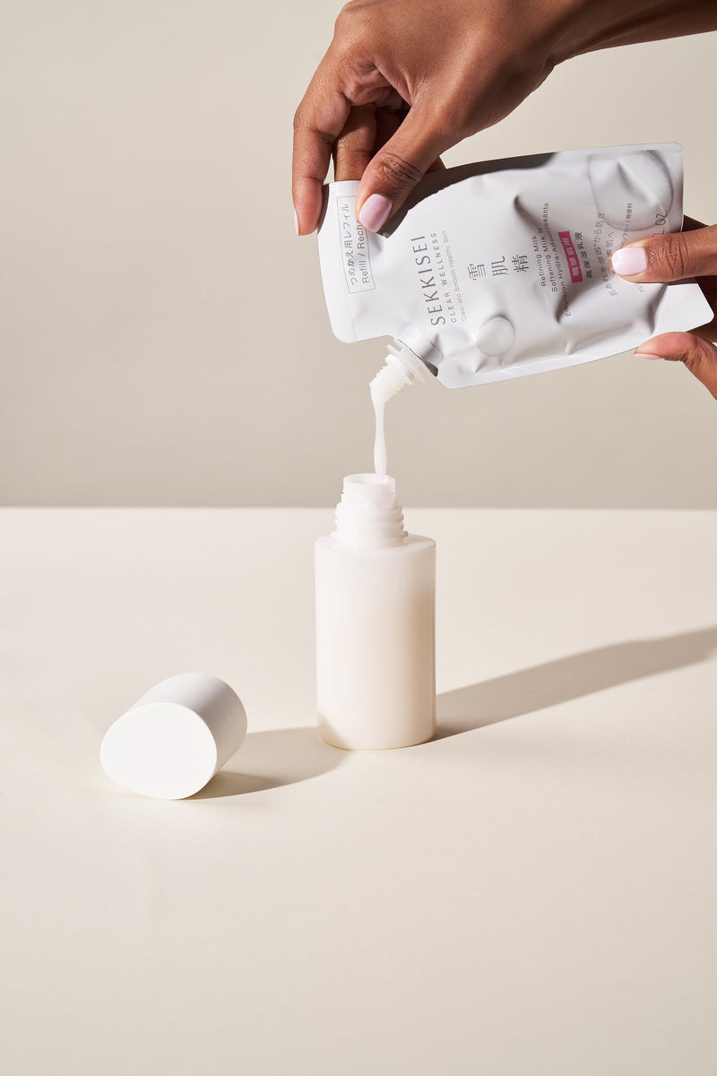 A person refilling Sekkisei Clear Wellness Softening Milk into product packaging. 