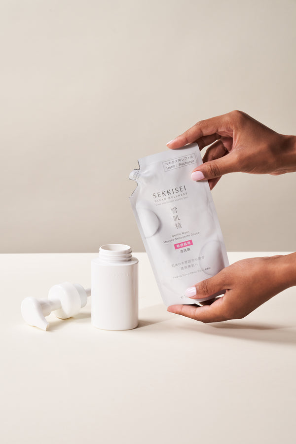 A person refilling Sekkisei Clear Wellness Gentle Wash into product packaging. 