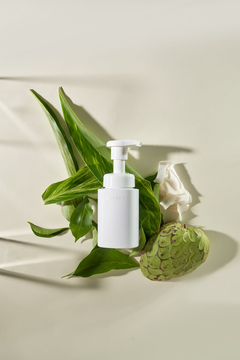 A product shot of Sekkisei Clear Wellness Gentle Wash against green nature. 